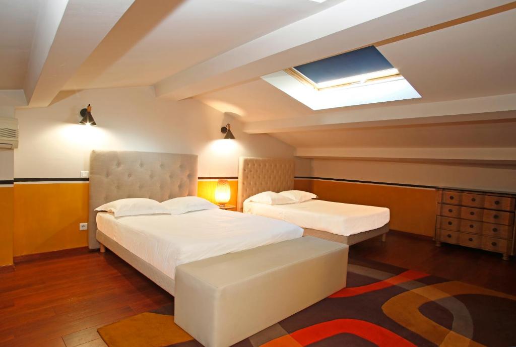 カルヴィにあるDuplex vue mer Christophe Colomb 140m2のベッド2台と天窓付きのホテルルームです。