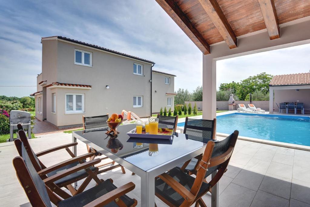 a patio with a table and chairs and a swimming pool at Villa Marcelia in Pula