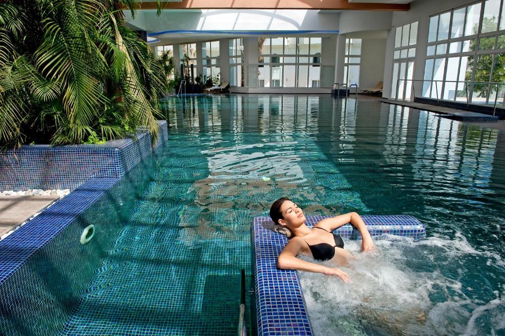 un joven nadando en una piscina en Royal Kenz Hotel Thalasso & Spa, en Port El Kantaoui