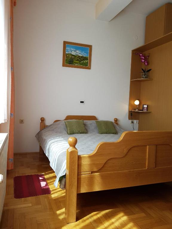 sypialnia z drewnianym łóżkiem w pokoju w obiekcie Prenociste Klas w mieście Pleternica