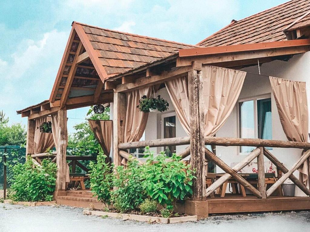 Casa de madera con valla y cortinas de madera en Villa Lukash, en Yanoshi