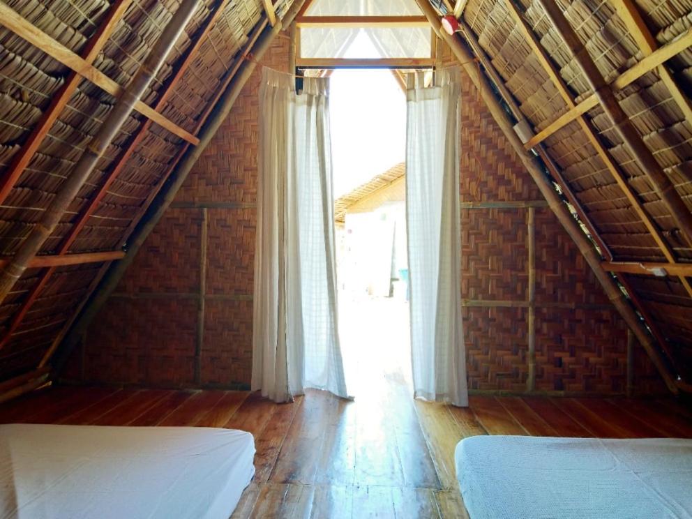 a attic room with two beds and a window at SEE-KEE-HOR Cafe and Hostel in Siquijor