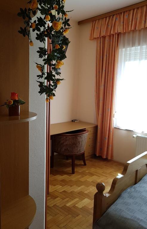 Pokój z łóżkiem i stołem z kwiatami w obiekcie Prenociste Klas w mieście Pleternica