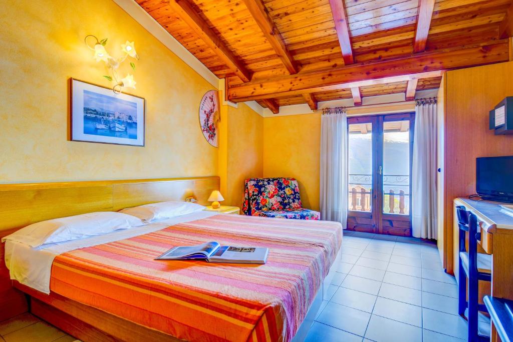 a bedroom with a bed with a book on it at Hotel Castello in Tignale