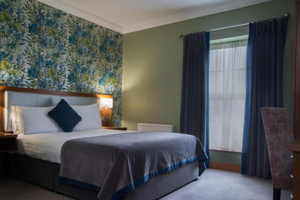 a hotel room with a bed and a window at Holyrood Hotel - Leisure Centre & The Spa at Orchids in Bundoran