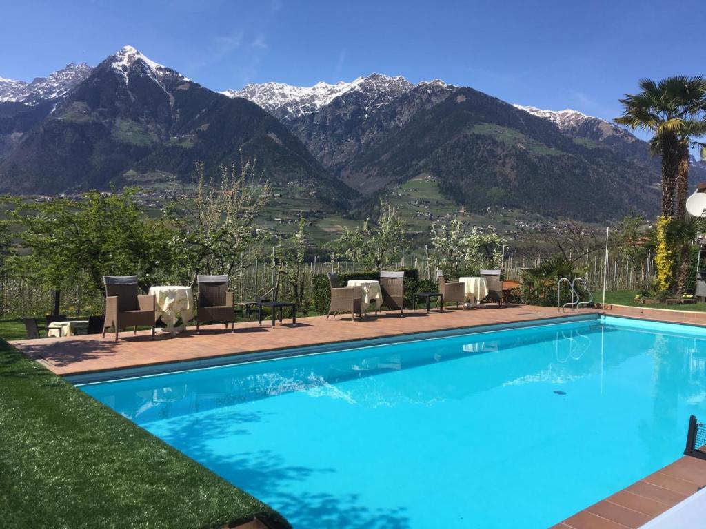 a swimming pool with mountains in the background at Pension Planta in Merano