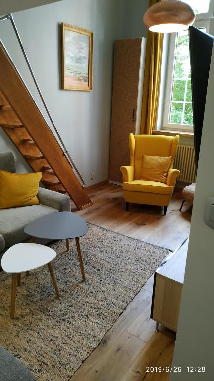 un soggiorno con un divano e una sedia di Apartament Ogarna 37 a Danzica