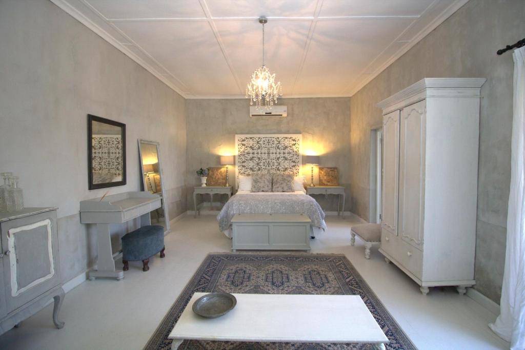 1 dormitorio con cama, escritorio y lavamanos en GABRIELLA'S en Riebeek-Kasteel