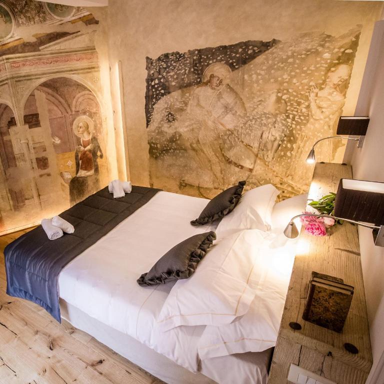 een slaapkamer met een bed met een schilderij aan de muur bij San Pier Novello in Oltrarno in Florence