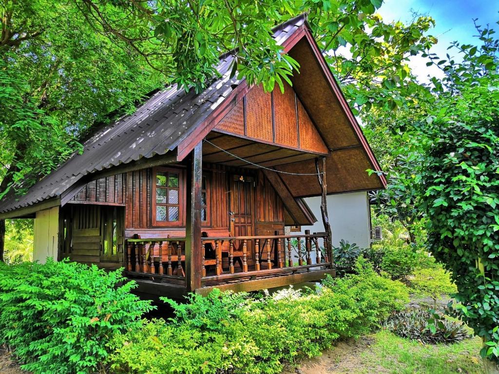 a small wooden house with a porch in a forest at Seashell Coconut Village Koh Tao in Ko Tao