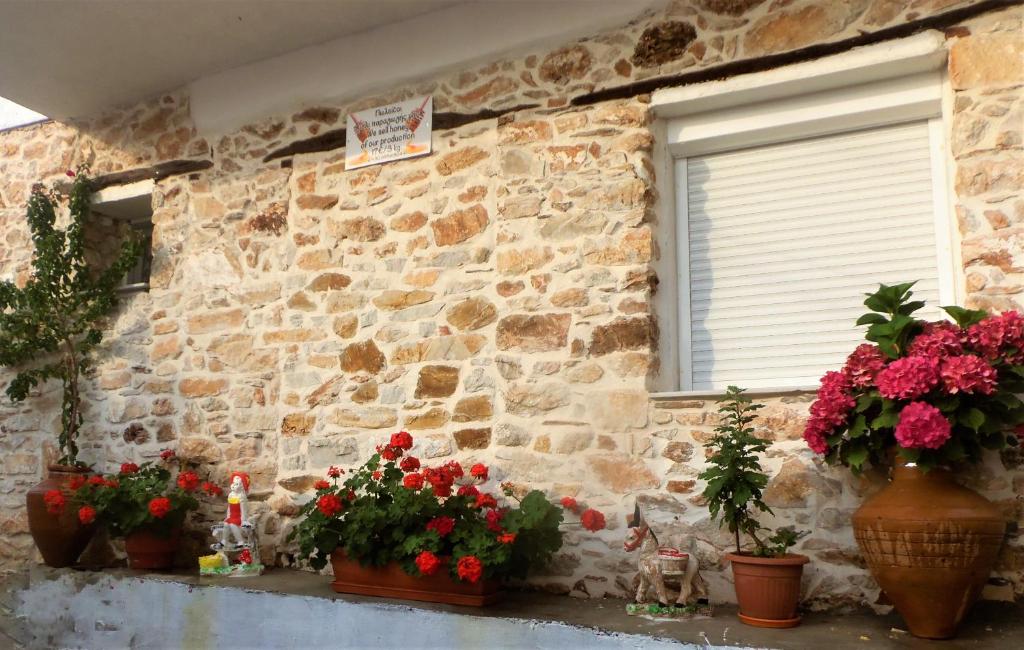 a stone wall with flowers in front of a window at The Place to be in Kallirákhi