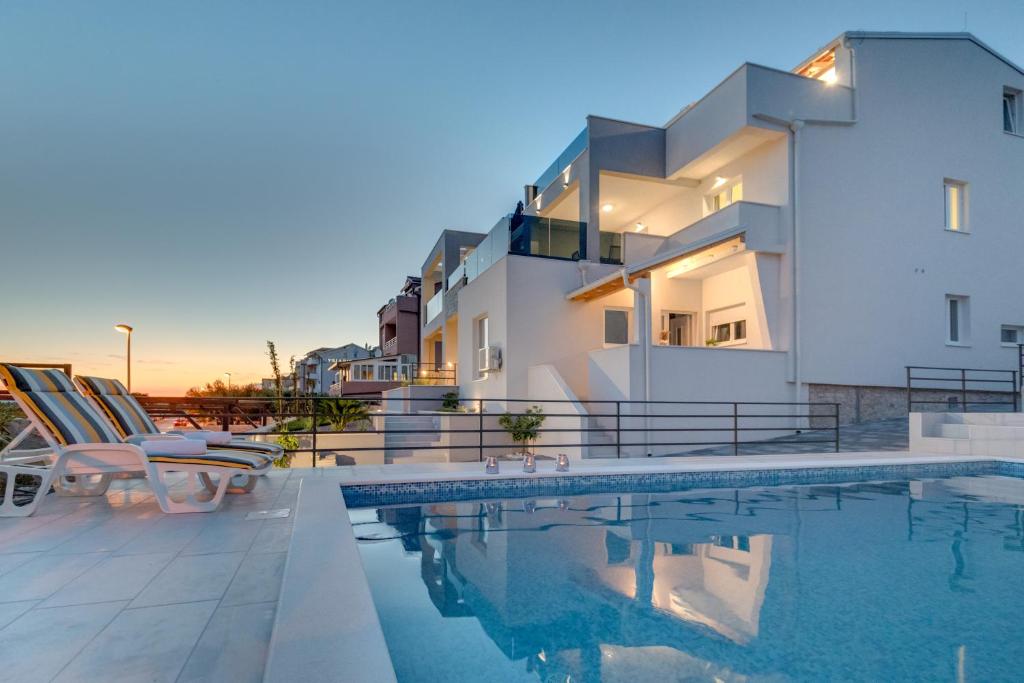 a villa with a swimming pool in front of a building at Villa Croatica II in Šibenik