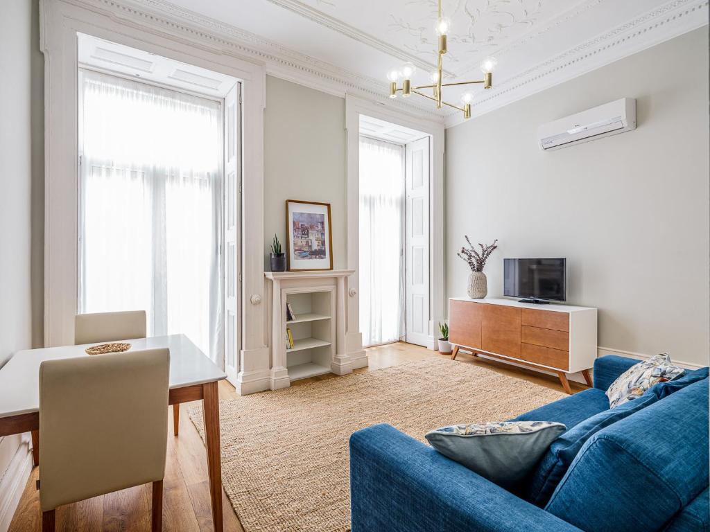 Oporto View Apartments في بورتو: غرفة معيشة مع أريكة زرقاء وطاولة