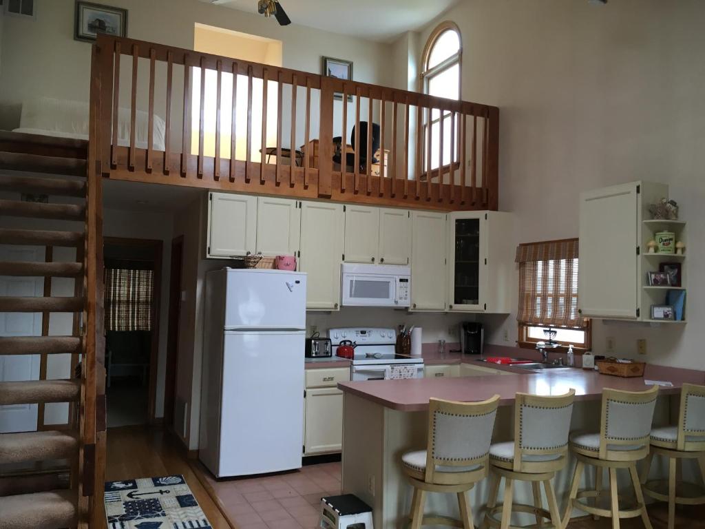 a kitchen with white cabinets and a white refrigerator at Blue Haven Bayside in Ocean City
