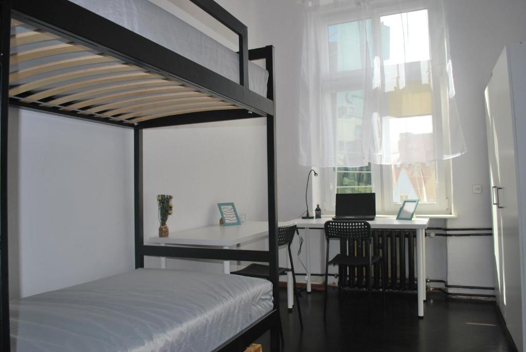 a bedroom with a bunk bed and a desk with a laptop at Pokoje w cichym mieszkaniu 50m od Rynku in Wrocław