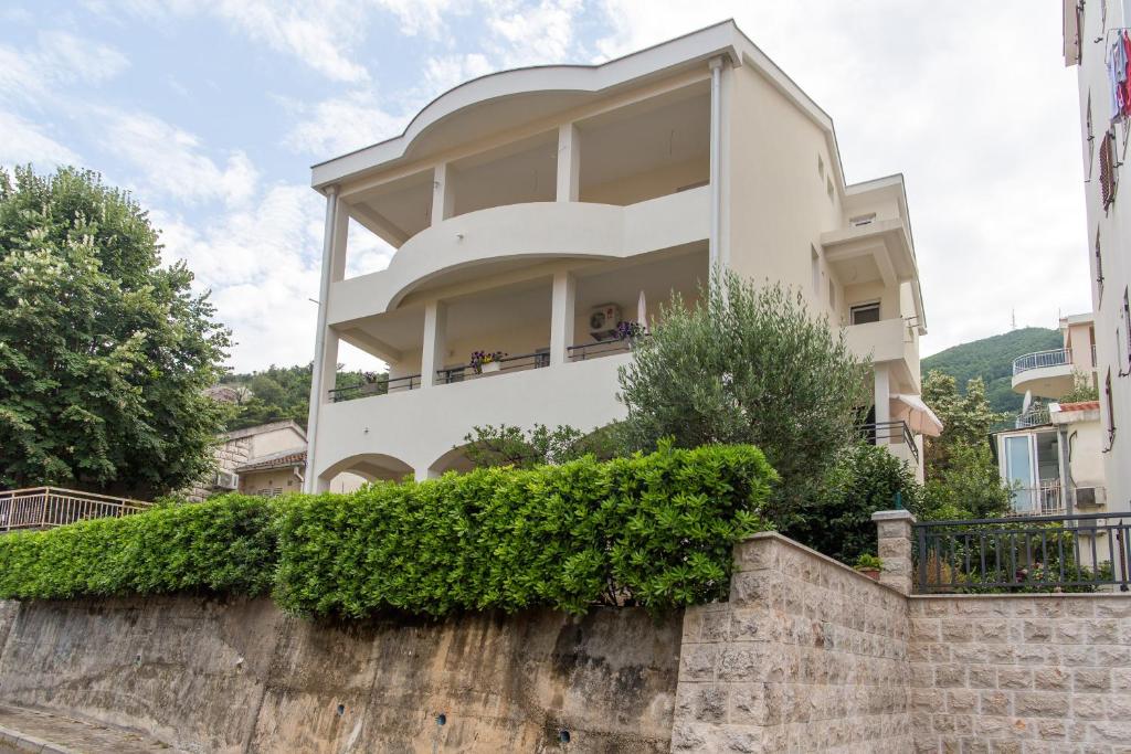 una grande casa bianca in cima a un muro di pietra di Guesthouse Dapcevic a Budua