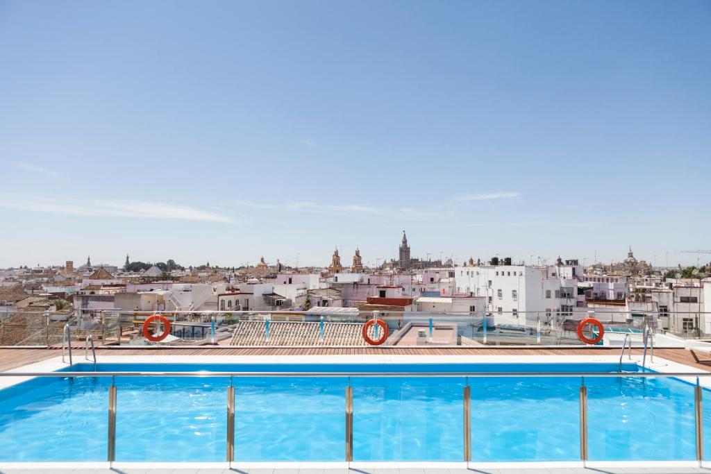 a large swimming pool on the roof of a building at Hotel Don Paco in Seville