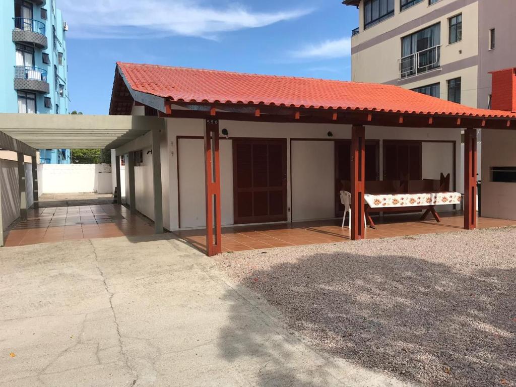 einem Pavillon mit rotem Dach vor einem Gebäude in der Unterkunft CASA ANTONIO HEILL 550 in Florianópolis