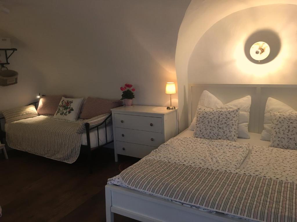 ein Schlafzimmer mit einem Bett, einem Stuhl und einer Kommode in der Unterkunft Ferienwohnungen Neusiedl am See in Neusiedl am See