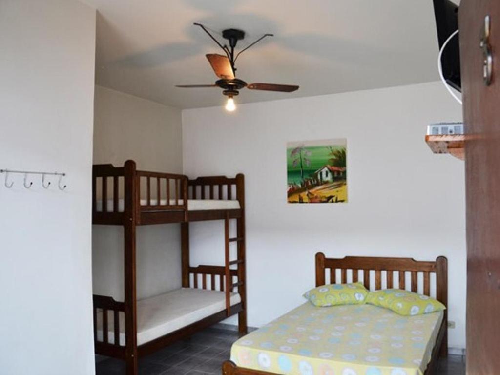 a bedroom with two bunk beds and a ceiling fan at Dolce Mar Ubatuba Suites in Ubatuba