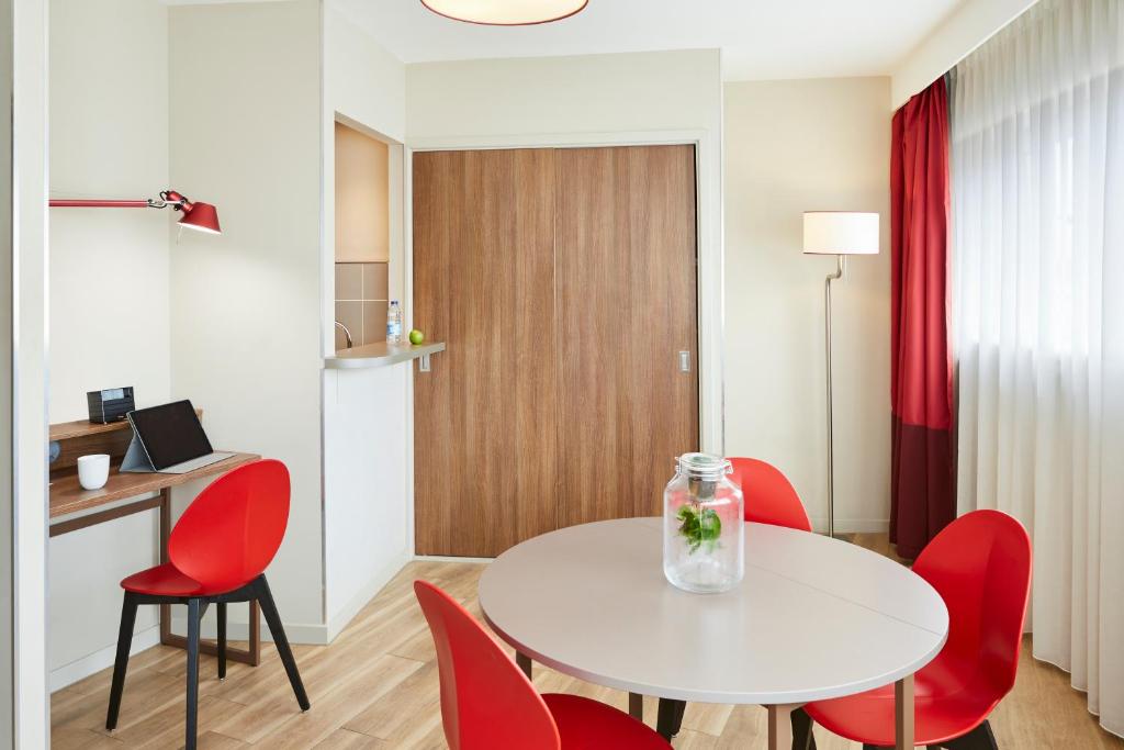 a room with a white table and red chairs at Aparthotel Adagio Birmingham City Centre in Birmingham