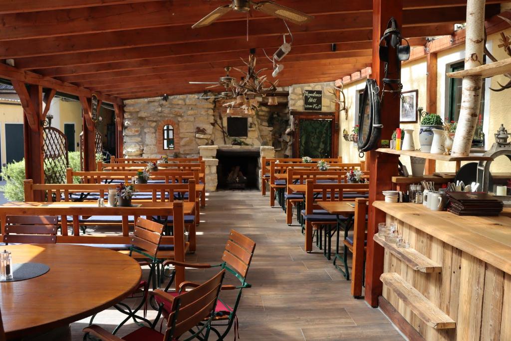 restauracja z drewnianymi stołami i krzesłami oraz kominkiem w obiekcie Landsteakhaus w mieście Marxheim