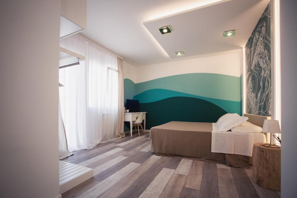 1 dormitorio con cama y pared verde en Residenza Ca’ Vittoria, en Chioggia