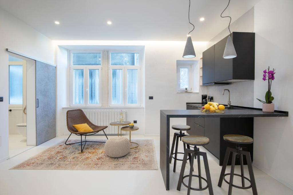 a kitchen with a counter and some stools in a room at Twins Idola Apartments in Pula
