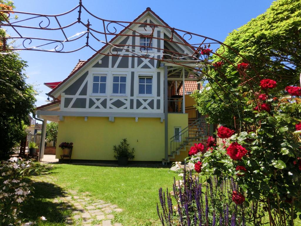 une maison avec une tourelle et des fleurs dans la cour dans l'établissement Ferienhaus Cartoonwerkstatt, à Kapellen-Drusweiler