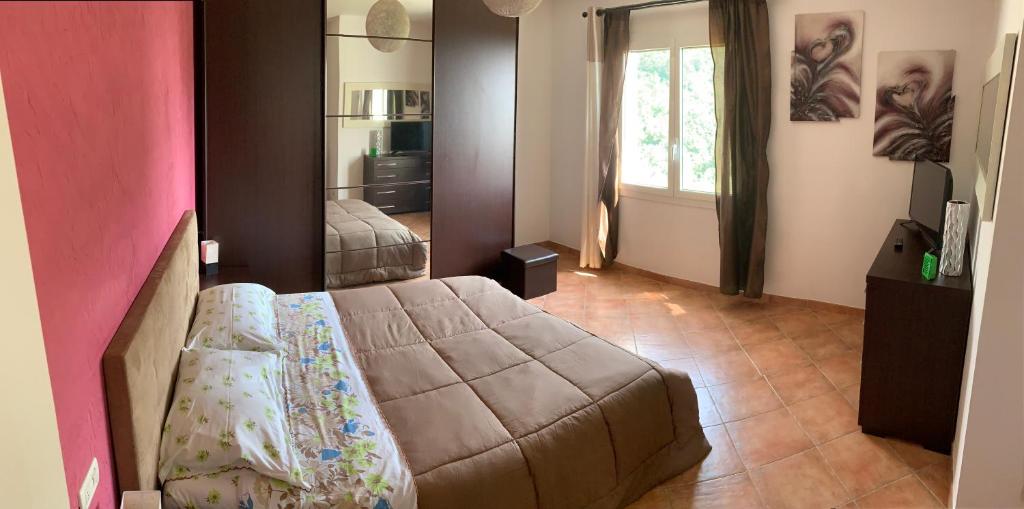 ein Schlafzimmer mit einem Bett und einem großen Fenster in der Unterkunft La porta del Sole in Seborga