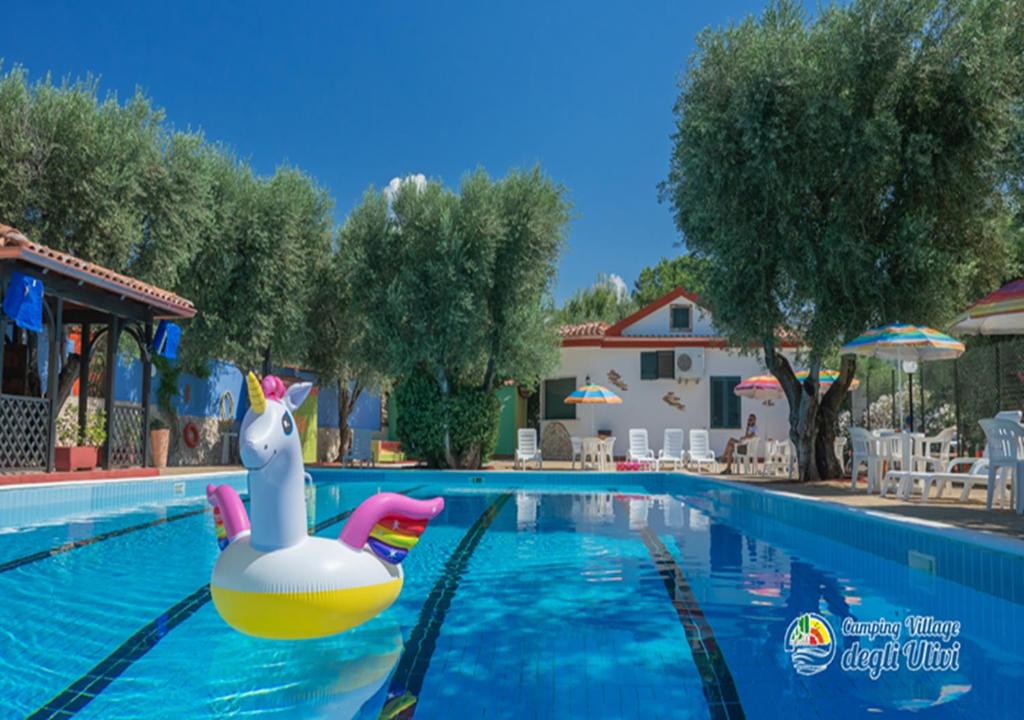 een zwembad in een resort met een rubberen eend in het water bij Camping Village degli Ulivi in Mattinata