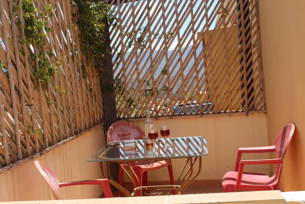 una mesa con sillas rojas y copas de vino en Oasis Montana peace in Tabernas Desert, en Tabernas