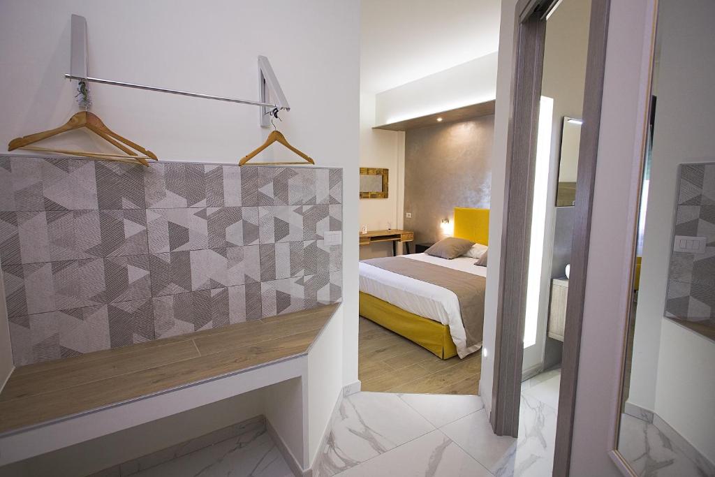 małą sypialnię z łóżkiem i lustrem w obiekcie PVrooms w mieście Campobasso