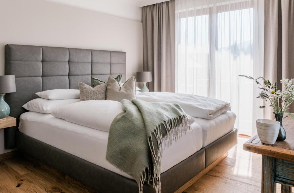 a bedroom with a large bed with a large window at Landhaus Steiner in Altenmarkt im Pongau