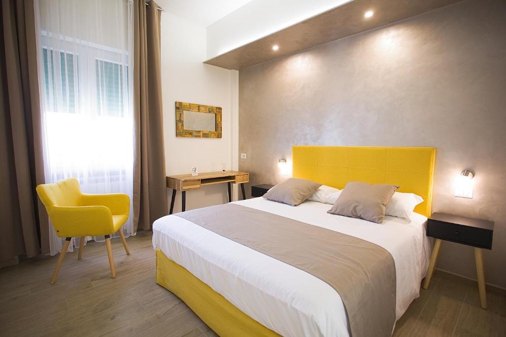 een slaapkamer met een groot bed met een geel hoofdeinde bij PVrooms in Campobasso