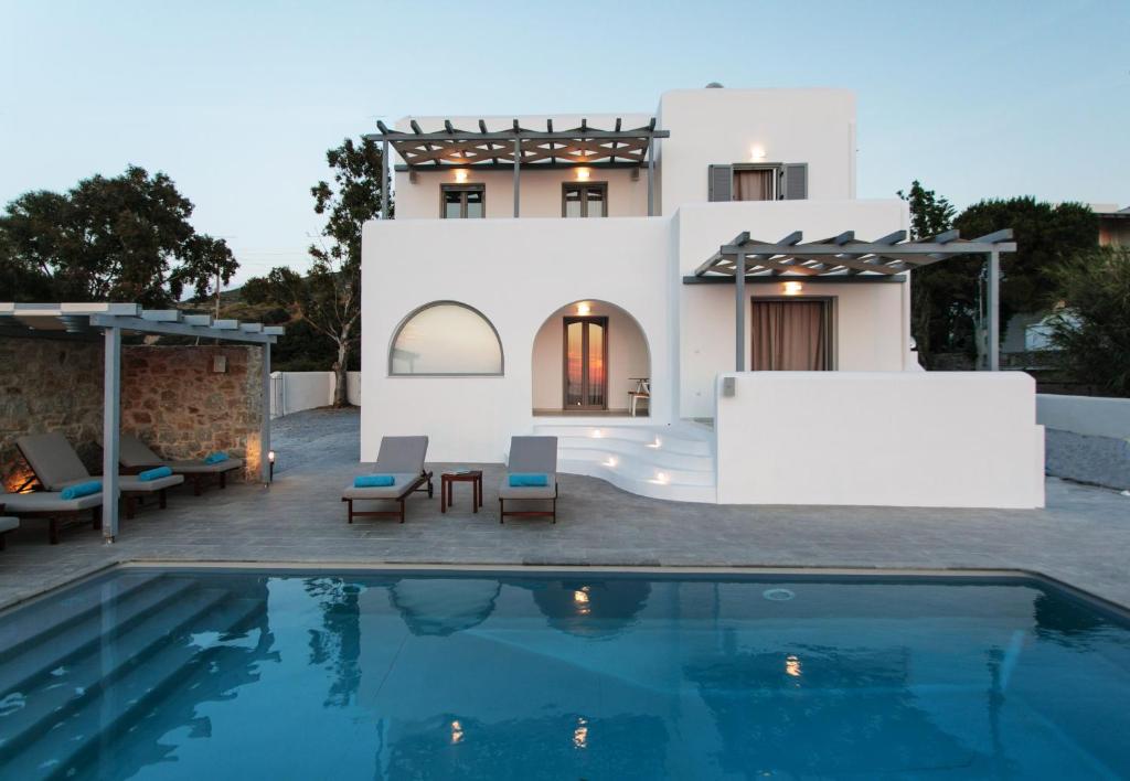 a villa with a swimming pool in front of a house at Naxos Infinity Villa and Suites in Naxos Chora