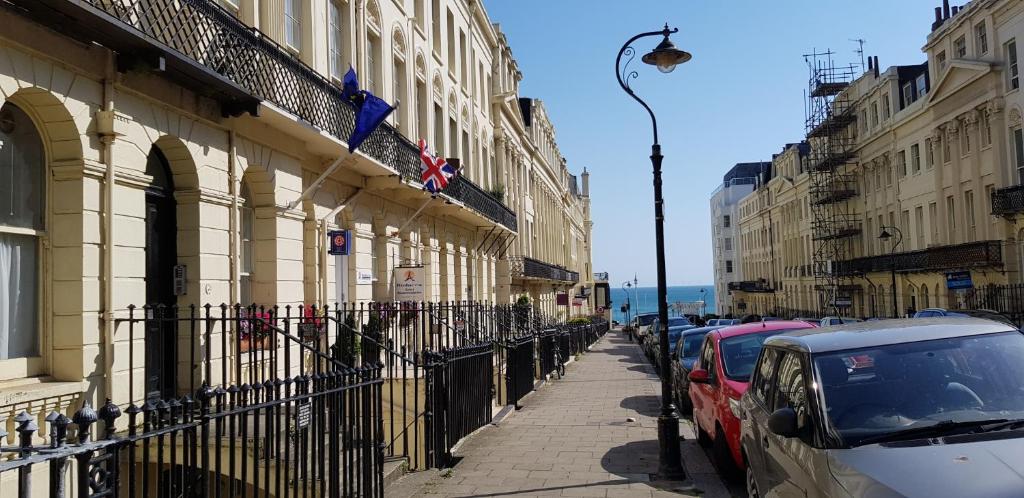 a street with cars parked next to a building at Andorra Guest Accommodation in Brighton & Hove