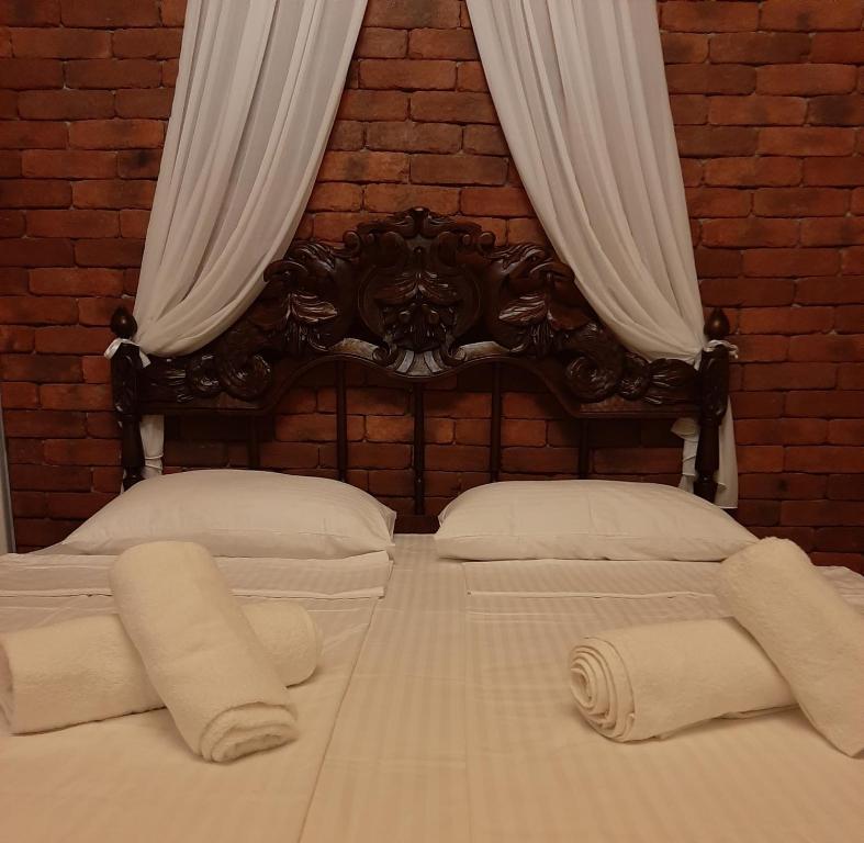 um quarto com 2 camas e almofadas brancas em Vintage Art Rooms em Tbilisi