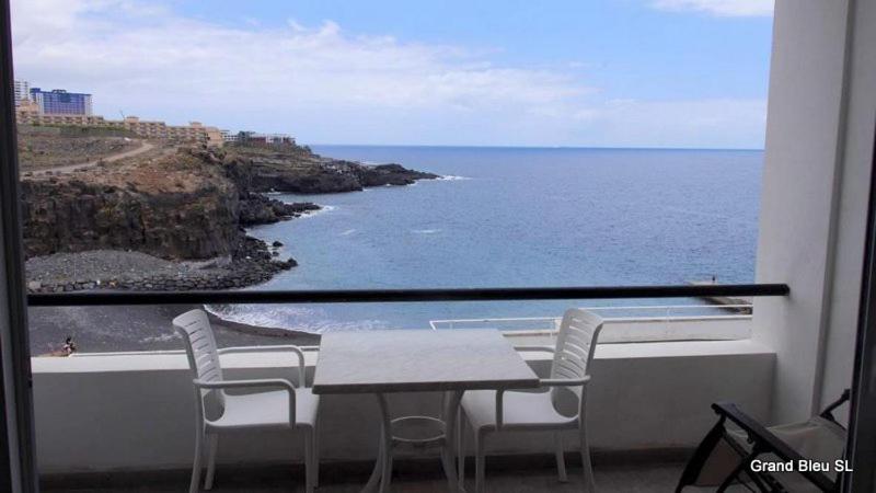 a table and chairs on a balcony with a view of the ocean at El Ancla - El Mar y La Playa in Callao Salvaje