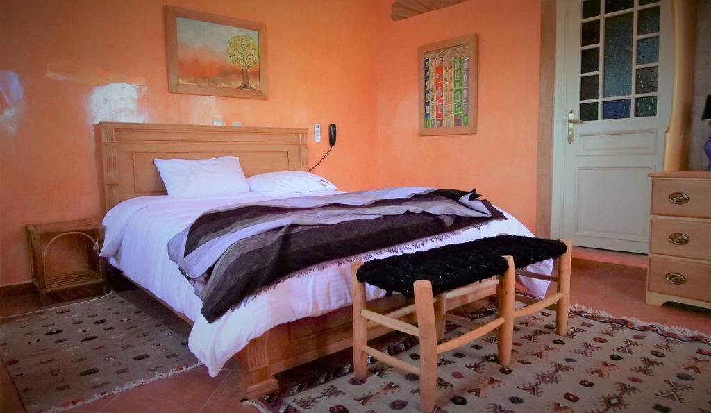 um quarto com uma cama grande e paredes cor-de-laranja em Ryad 91 em Casablanca