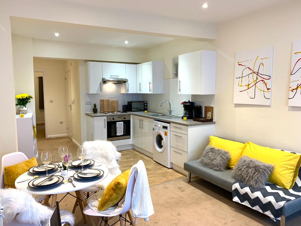 Il comprend une cuisine et un salon avec une table et des chaises. dans l'établissement Eastbourne Beach Pier Apartment, à Eastbourne