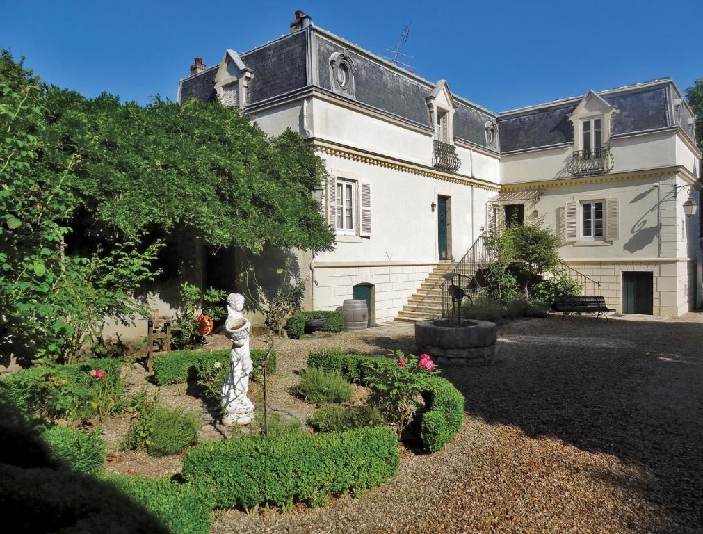 duży biały dom z posągiem w ogrodzie w obiekcie La Maison Chaudenay w mieście Chaudenay