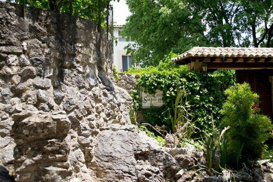 un mur en pierre avec un panneau. dans l'établissement Hostal Caseria San José de Hutar, à Hútar