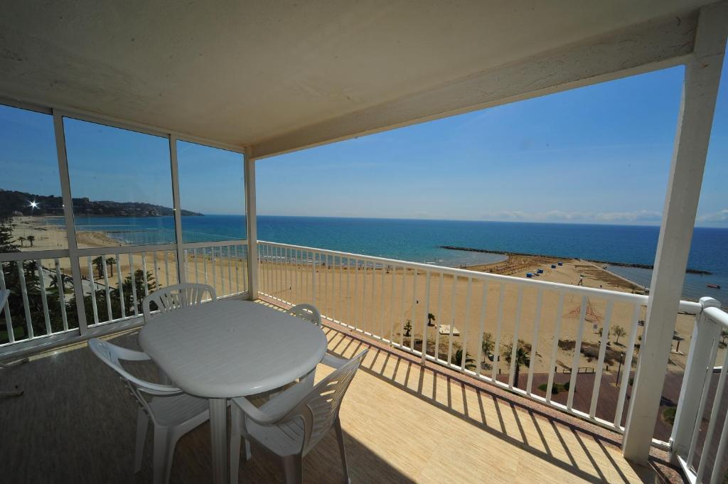 balcón con mesa y sillas y vistas a la playa en Coimbra vista mar Orangecosta, en Benicàssim
