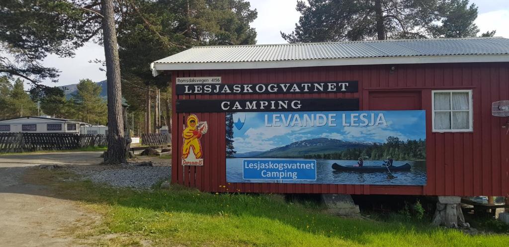 een bord aan de zijkant van een rood gebouw bij Lesjaskogsvatnet Camping in Lesjaskog