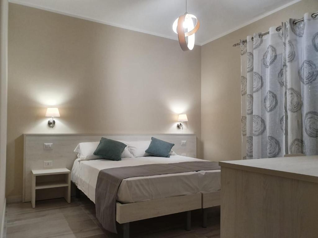 a bedroom with a bed and a shower curtain at Oikia Rooms in Parghelia