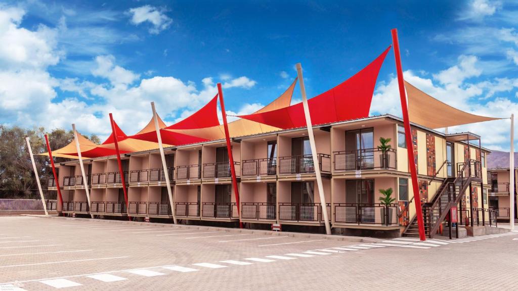 um edifício com telhados vermelhos e amarelos numa rua em Hotel Vento em Copiapó