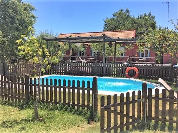 a wooden fence with a pool in front of a house at Karma House in Casares