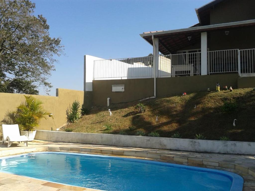 a swimming pool in front of a house at Chácara Recanto Paraíso in Serra Negra