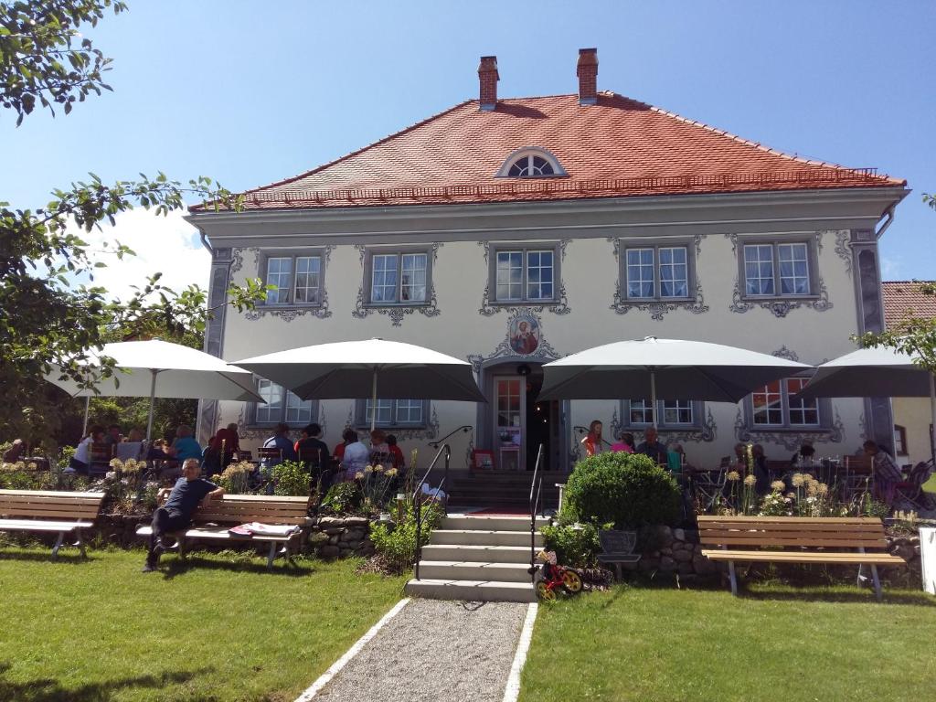 a building with tables and umbrellas in front of it at s'Himmelreich in Leutkirch im Allgäu